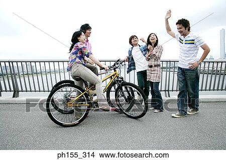 Picture - Three young men and two young women talking. Fotosearch