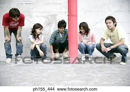 Picture - Three young men and two young women making a game plan. Fotosearch