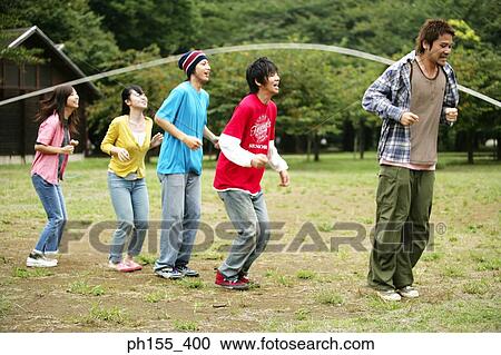 Three young men and two young women playing jump rope View Large Photo Image Stock Image - Three young men and two young women playing jump rope. Fotosearch