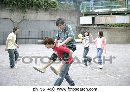 Stock Image - Three young men and two young women playing. Fotosearch