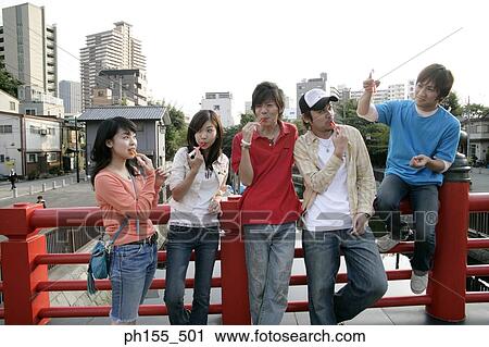 Three young men and two young women near a railing View Large Photo Image Stock Image - Three young men and two young women near a railing. Fotosearch