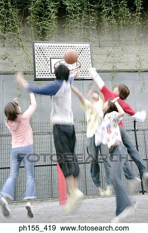 Stock Photo - Three young men and two young women playing basketball. Fotosearch