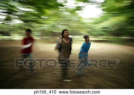 Three young men playing in a park View Large Photo Image Stock Image - Three young men playing in a park. Fotosearch