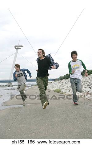 Three young men running near a river View Large Photo Image Stock Photograph - Three young men running near a river. Fotosearch