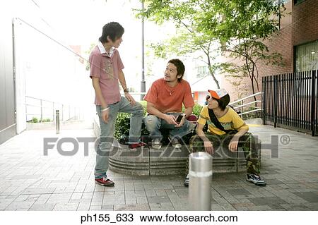 Three young men sitting together and talking View Large Photo Image Stock Image - Three young men sitting together and talking. Fotosearch