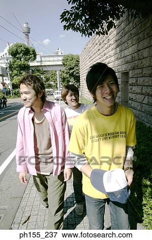 Three young men walking on a footpath View Large Photo Image Stock Photo - Three young men walking on a footpath. Fotosearch