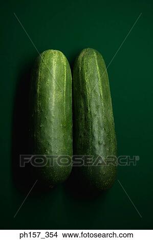 Picture - Two cucumbers on a green surface. Fotosearch