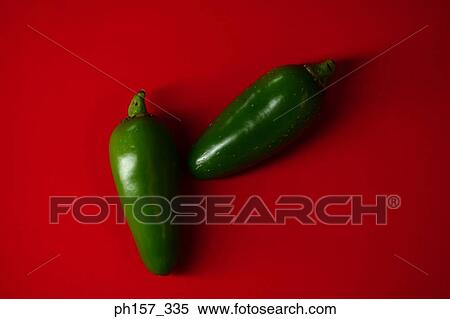 Two green chilli on a red surface View Large Photo Image Stock Photography - Two green chilli on a red surface. Fotosearch