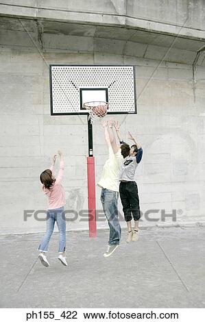 Two young men and a young woman playing basketball View Large Photo Image Stock Image - Two young men and a young woman playing basketball. Fotosearch
