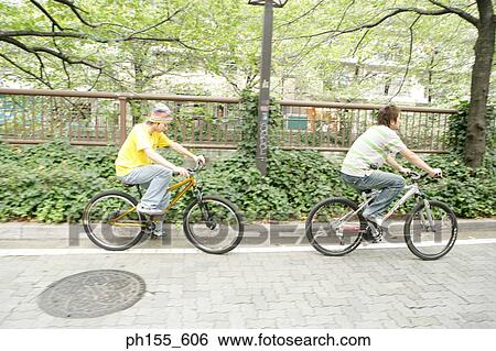 Two young men cycling View Large Photo Image Stock Photograph - Two young men cycling. Fotosearch