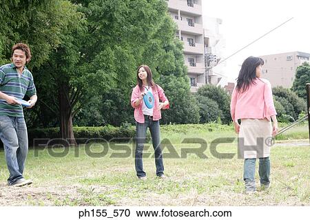 Two young women and a young man playing with plastic discs View Large Photo Image Stock Image - Two young women and a young man playing with plastic discs. Fotosearch