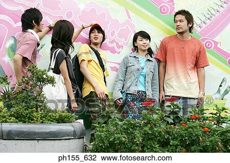Two young women and three young men standing together View Large Photo Image Stock Image - Two young women and three young men standing together. Fotosearch