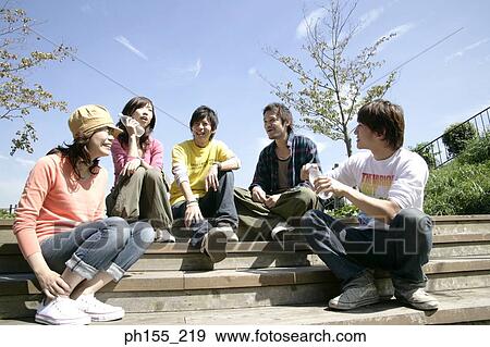 Two young women and three young men sitting on steps and smiling View Large Photo Image Stock Photo - Two young women and three young men sitting on steps and smiling. Fotosearch