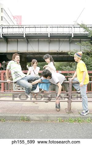 Two young women and three young men near a railing View Large Photo Image Stock Photo - Two young women and three young men near a railing. Fotosearch