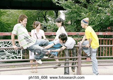 Two young women and three young men near a railing View Large Photo Image Stock Photo - Two young women and three young men near a railing. Fotosearch