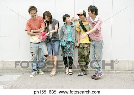 Two young women and three young men standing together View Large Photo Image Stock Photography - Two young women and three young men standing together. Fotosearch
