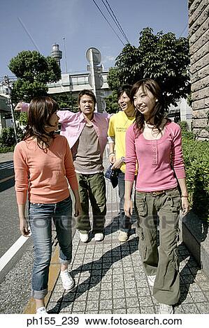 Two young women and two young men walking on a footpath View Large Photo Image Stock Photo - Two young women and two young men walking on a footpath. Fotosearch