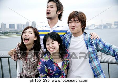 Two young women and two young men leaning against a railing View Large Photo Image Stock Photography - Two young women and two young men leaning against a railing. Fotosearch