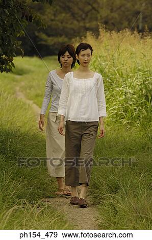 Stock Photo - Two young women walking on a trail. Fotosearch