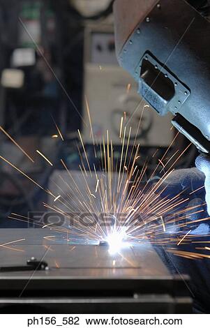 Stock Image - Welder welding in a workshop. Fotosearch