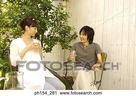 Stock Image - Young couple holding glasses of water. Fotosearch