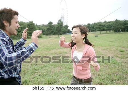 Young couple playing in a park and smiling View Large Photo Image Stock Photography - Young couple playing in a park and smiling. Fotosearch