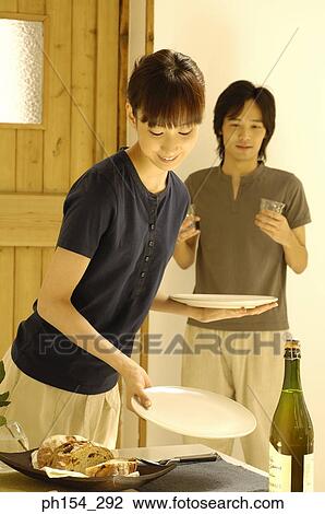 Stock Image - Young couple preparing for dining. Fotosearch