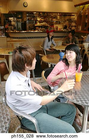 Young couple sitting together in a restaurant View Large Photo Image Stock Photo - Young couple sitting together in a restaurant. Fotosearch