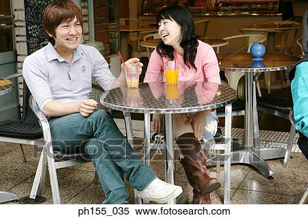 Young couple sitting together in a restaurant and smiling View Large Photo Image Stock Photography - Young couple sitting together in a restaurant and smiling. Fotosearch