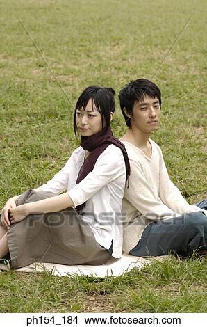 Picture - Young couple sitting together on a mat. Fotosearch