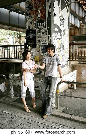 Stock Photo - Young couple standing and talking. Fotosearch