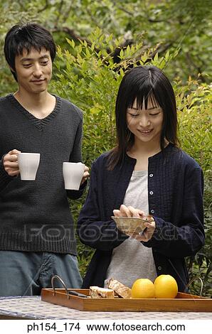 Young couple standing beside a table View Large Photo Image Picture - Young couple standing beside a table. Fotosearch