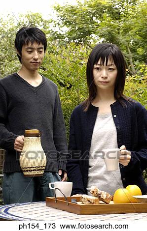 Young couple standing beside a table View Large Photo Image Stock Image - Young couple standing beside a table. Fotosearch