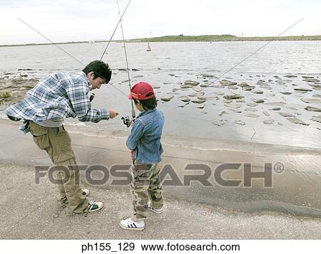 Young man and his son holding fishing rods View Large Photo Image Stock Photo - Young man and his son holding fishing rods. Fotosearch