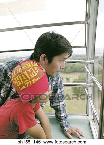 Young man and his son looking out of a trolley View Large Photo Image Stock Photograph - Young man and his son looking out of a trolley. Fotosearch