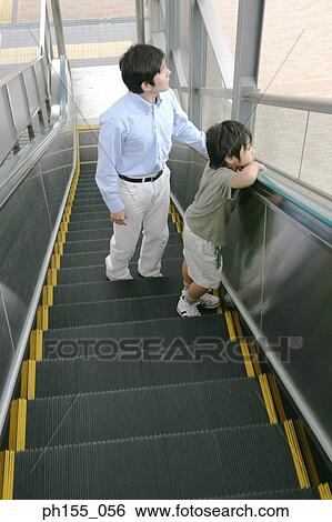 Young man and his son on an escalator View Large Photo Image Stock Photograph - Young man and his son on an escalator. Fotosearch