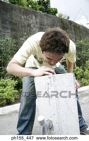 Stock Photo - Young man drinking water from a drinking fountain. Fotosearch