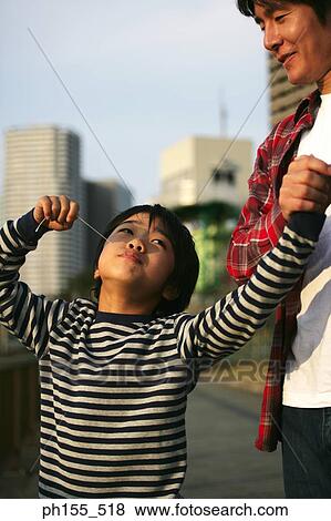 Young man holding his son's hand with his son eating candy View Large Photo Image Stock Photo - Young man holding his son's hand with his son eating candy. Fotosearch