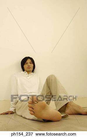 Stock Photo - Young man leaning against a wall. Fotosearch