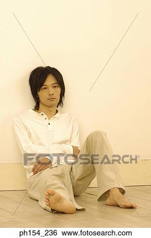 Young man leaning against a wall View Large Photo Image Stock Photograph - Young man leaning against a wall. Fotosearch