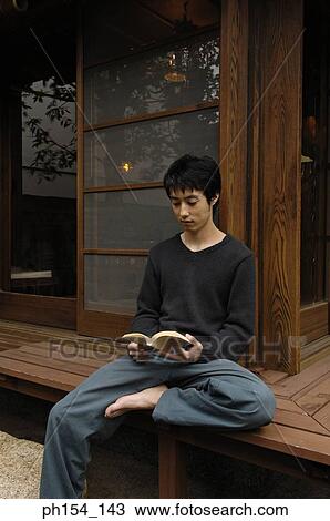 Young man reading a book View Large Photo Image Stock Image - Young man reading a book. Fotosearch
