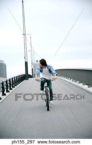 Young man riding a cycle View Large Photo Image Stock Photo - Young man riding a cycle. Fotosearch