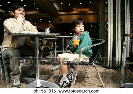 Young man sitting in a restaurant with his son View Large Photo Image Stock Photography - Young man sitting in a restaurant with his son. Fotosearch