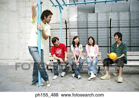 Young man sitting on a bench and holding a ball View Large Photo Image Stock Photo - Young man sitting on a bench and holding a ball. Fotosearch