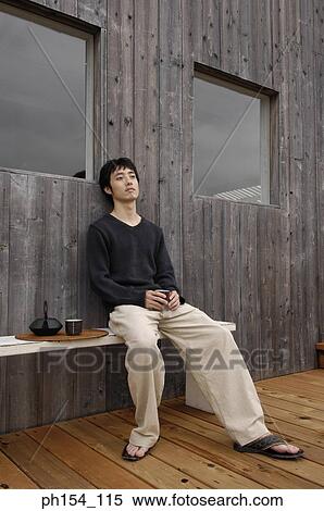 Young man sitting on a bench View Large Photo Image Stock Photography - Young man sitting on a bench. Fotosearch