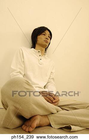 Young man sitting on the floor with his legs crossed View Large Photo Image Stock Photo - Young man sitting on the floor with his legs crossed. Fotosearch