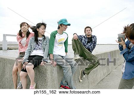 Young man taking a picture of four people View Large Photo Image Stock Image - Young man taking a picture of four people. Fotosearch