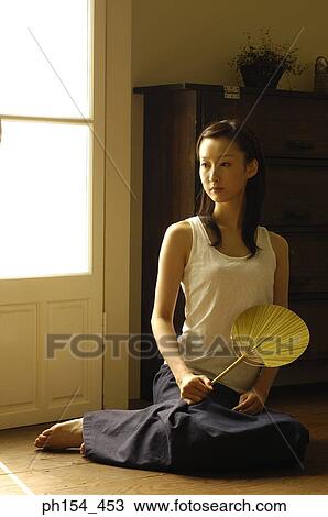 Young woman holding a fan View Large Photo Image Stock Image - Young woman holding a fan. Fotosearch
