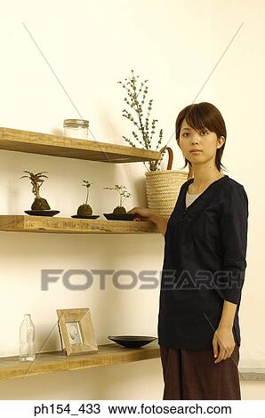 Young woman holding a potted plant View Large Photo Image Stock Image - Young woman holding a potted plant. Fotosearch