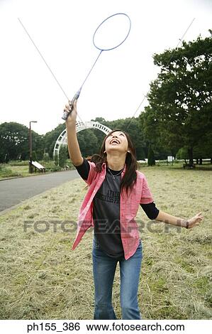 Stock Photograph - Young woman playing badminton. Fotosearch